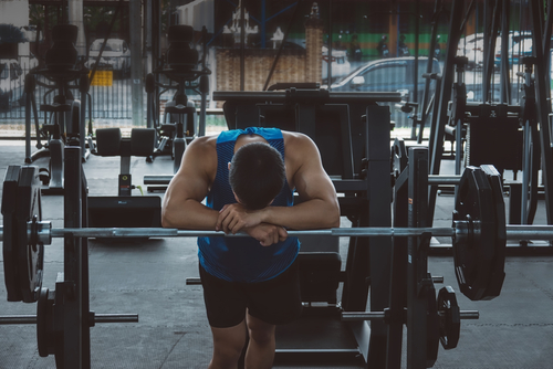 A well-trained athlete feels fatigued after completing the next set of lifting the barbell.